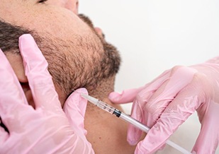 Man receiving BOTOX injection in his jaw