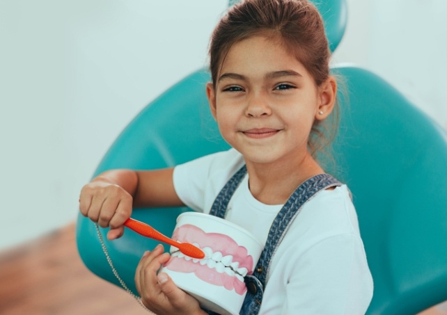 Child learning to brush teeth during general and preventive dentistry visit