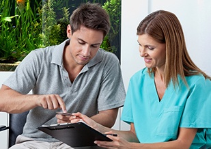 A man paying the cost of cosmetic dentistry