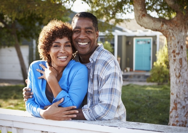 man and woman smiling after dental crown supported fixed bridge dental restoration