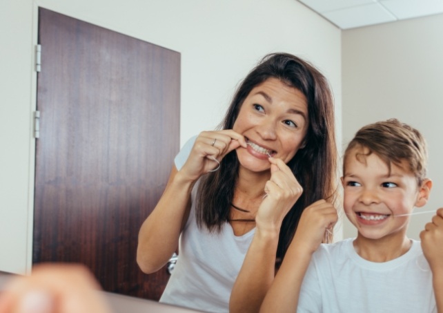 Mother and child flossing teeth to prevent dental emergencies