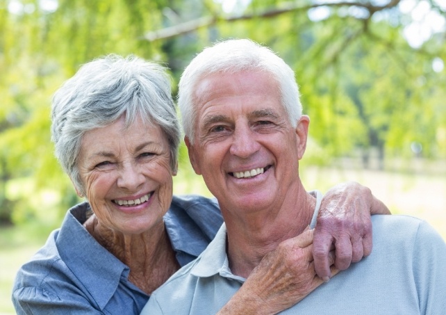 Man and woman smiling after tooth extractions