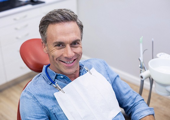 Male dental patient smiling after tooth extraction in Virginia Beach, VA