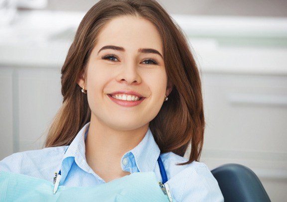 Smiling female dental patient in dental chair