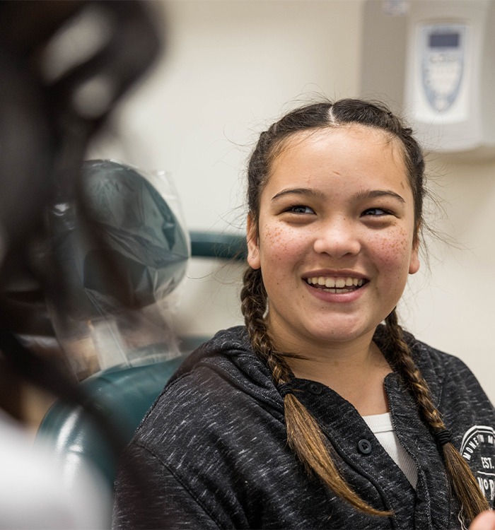 Woman smiling after replacing teeth with dental implants