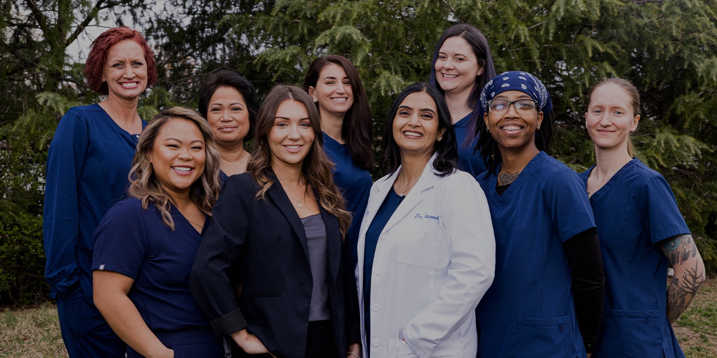 Woman in dentistry chair smiling a dental team member