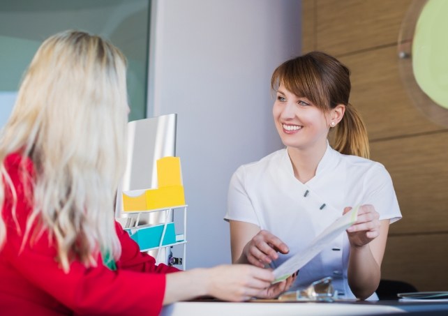 Dental team member and patient reviewing dental insurance