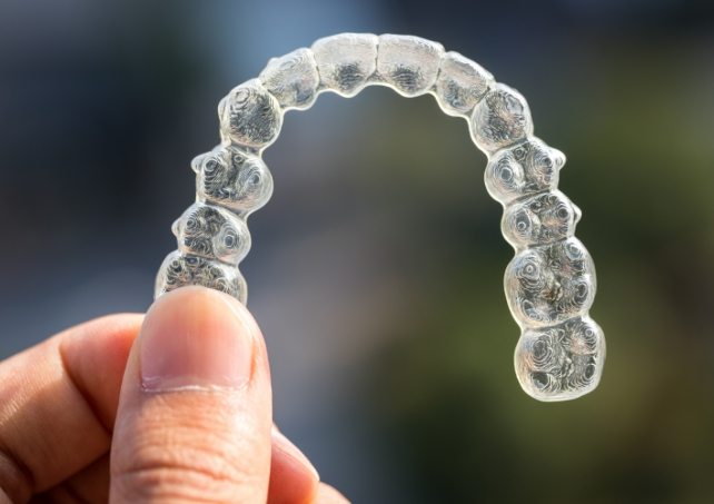 A woman putting in her aligners