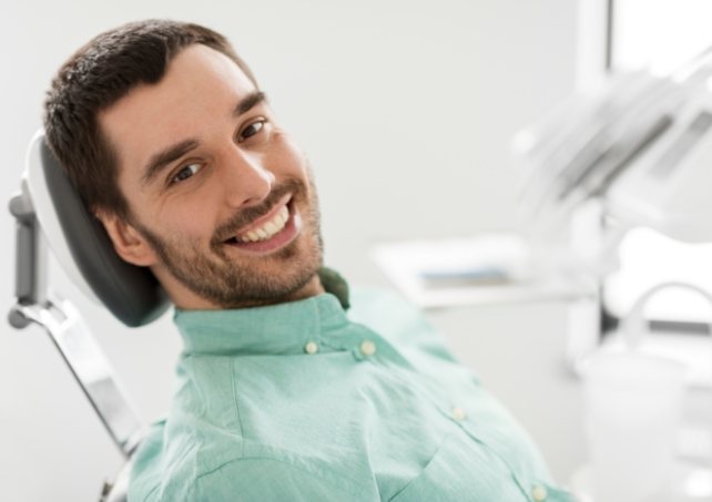 Man in dental chair for preventive dentistry teeth cleaning