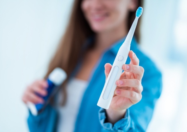 Woman using at home dental hygiene products