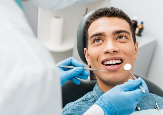 Man discussing preventive dentistry frequently asked questions with dentist