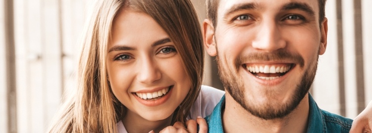 Man and woman with healthy smiles after gum disease treatment