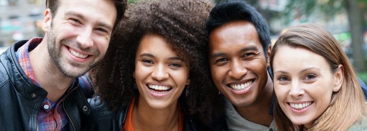 Four friends smiling after emergency dentistry