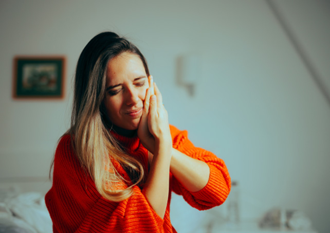 a person holding their jaw in pain
