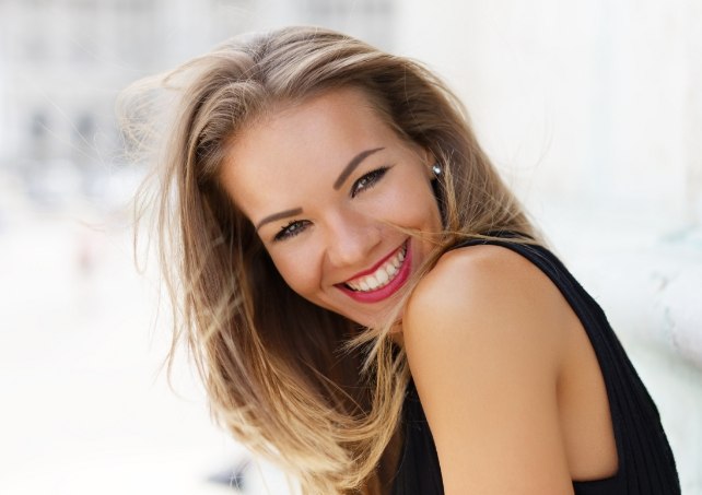 Woman with gorgeous smile after porcelain veneer treatment