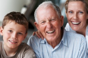 young boy, elederly man and young woman smiling