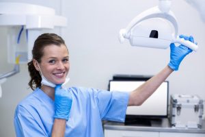 a dental assistant moving an X-ray machine