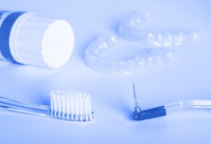 Invisalign aligners surrounded by oral hygiene products