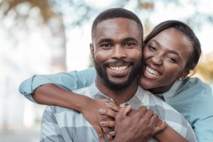 a couple smiling with beautiful and healthy teeth