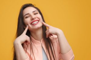 Happy woman pointing at teeth.