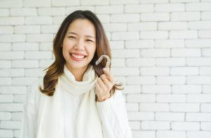 woman holding Invisalign clear aligner