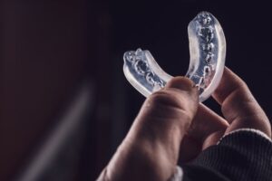 Athlete holding up his mouthguard