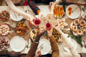 family clinking glasses during holiday dinner