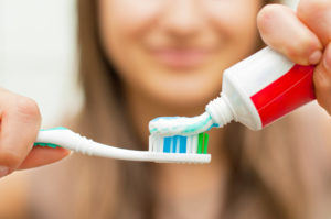 woman smiling brushing her teeth