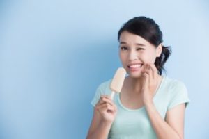 Woman eating a popsicle in pain